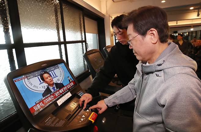 헬스장 찾은 이재명, 러닝머신 화면에 임종석이… - 더불어민주당 이재명 대표가 28일 서울 홍제동의 한 헬스장에서 열린 간담회에서 러닝머신 이용법을 안내받고 있다. 기구 모니터에서 임종석 전 청와대 비서실장이 공천 배제 결정에 반발하는 기자회견 생중계 장면이 나오고 있다. /국회사진기자단