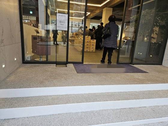 서울 성동구에 위치한 한 와인 가게에서 손님들이 홍채 인증을 위해 길게 줄을 서 있다. 줄을 계속 서 있기 힘들어 간이 의자를 가져와 기다리는 사람도 있었다. 신혜연 기자