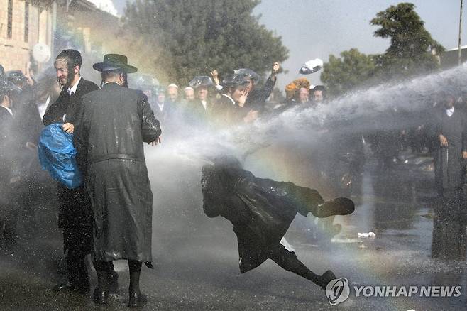 2017년 9월 12일 당시 이스라엘 예루살렘에서 군 복무 거부 시위를 벌이던 하레디들이 경찰의 물대포를 맞는 모습. [EPA=연합뉴스 자료사진. 재판매 및 DB 금지]