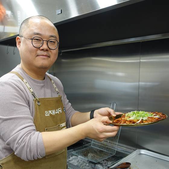 돼지불고기 접시를 들고 있는 안재만씨. [사진 이택희]