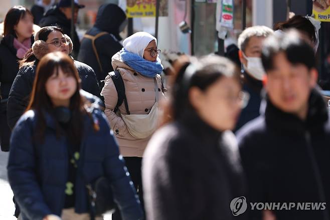 서울지역 아침 기온이 영하권을 기록하는 등 꽃샘추위가 기승을 부린 지난 1일 오후 서울 중구 명동에서 두꺼운 옷차림의 관광객이 길을 지나고 있다. [연합뉴스 자료사진]