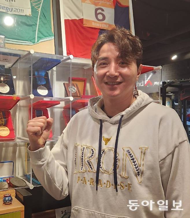 ‘철인’ 김건우가 선수 시절 획득한 메달을 배경으로 카메라 앞에 섰다. 이헌재 기자 uni@donga.com