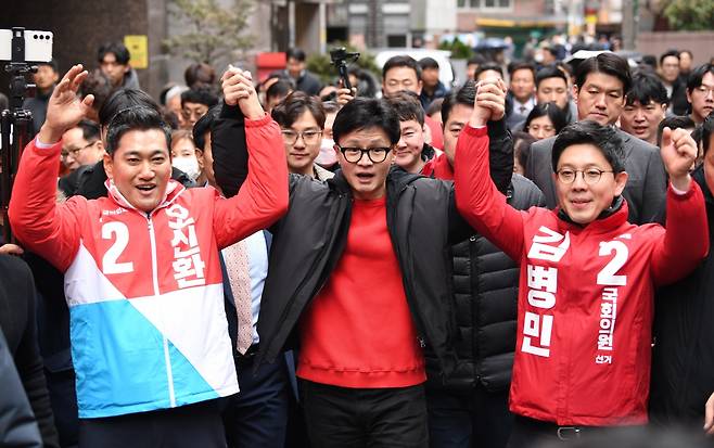 한동훈 국민의힘 비상대책위원장이 지난 20일 오후 서울 광진구 일대 골목에서 광진구 단수공천을 받은 오신환(왼쪽)·김병민 후보의 손을 들어 보이고 있다./ 사진=연합뉴스