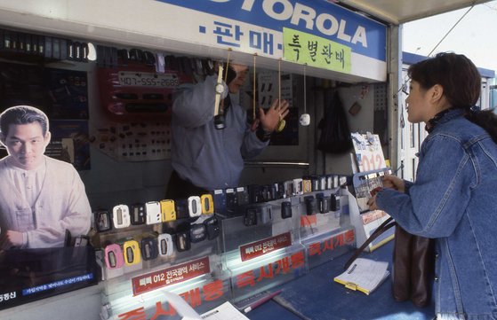 1996년 길거리 가판대에서 판매하는 무선호출기(삐삐)를 구매하려는 한 시민의 모습.