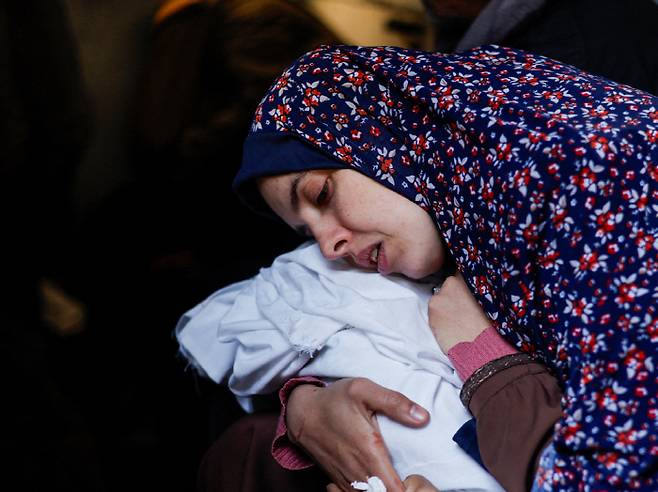 3일(현지시각) 이스라엘군의 공습으로 쌍둥이와 남편을 잃은 라니아 아부 안자가 죽은 아기를 안고 슬퍼하고 있다. 로이터연합뉴스