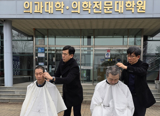 5일 오전 강원대학교 의과대학 앞에서 의대 교수들이 삭발식을 열고 대학 측의 증원 방침에 반발하고 있다.앞서 강원대는 교육부에 현재 49명에서 140명으로 의대 정원을 늘려달라고 요청했다. 연합뉴스