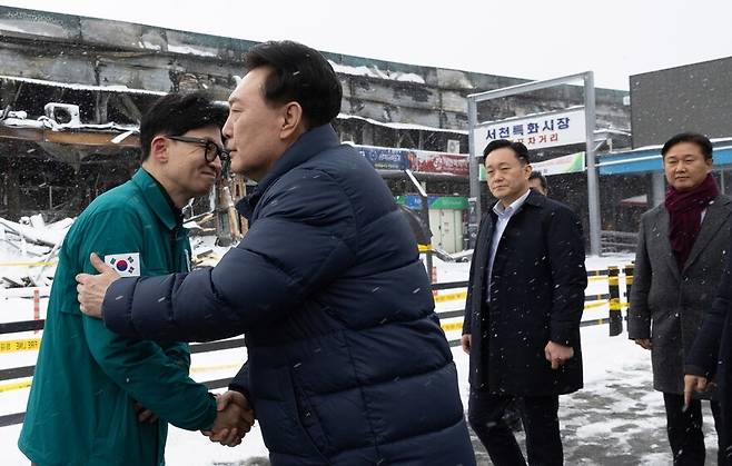 윤석열 대통령과 한동훈 국민의힘 비상대책위원장이 2024년 1월23일 충남 서천 화재현장에서 만나 악수하고 있다. 연합뉴스