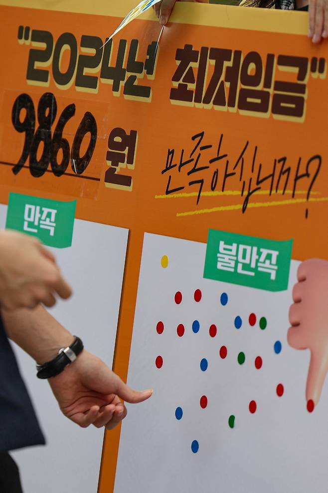 서울 종로구 마로니에공원에서 한 시민이 2023년 7월 19일 결정된 최저임금에 관한 의견을 묻는 스티커 설문에 참여하고 있다. 최저임금위원회는 2024년도 최저임금을 2023년(9620원)보다 2.5% 인상된 9860원으로 결정했다. 사진=연합뉴스