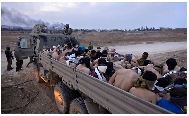 가자지구에서 이스라엘군이 팔레스타인 수감자들을 나체 상태로 눈을 가리게 한 뒤 트럭에 태우고 있다. 에이피 통신