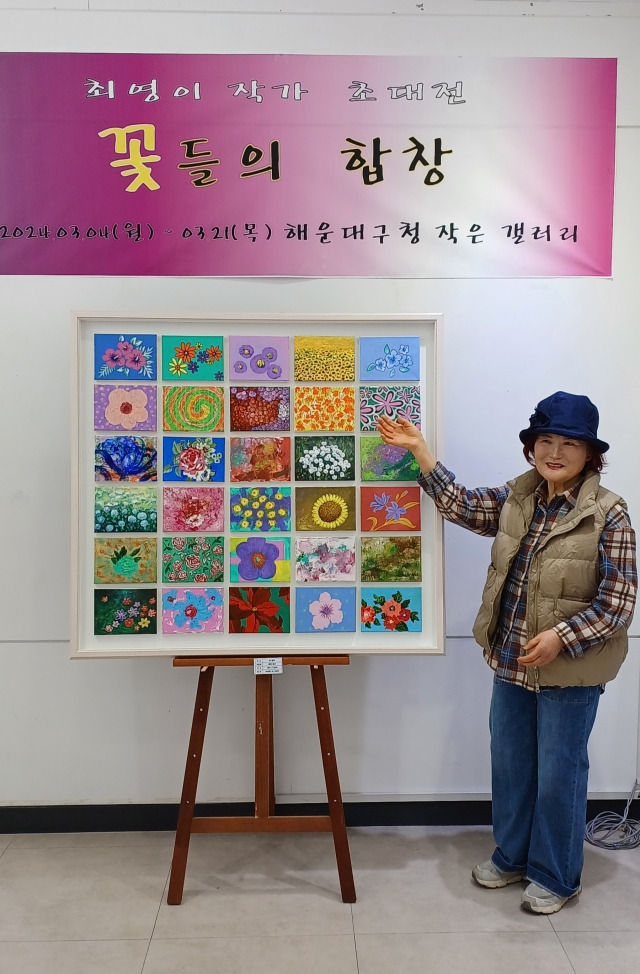 지난 4일부터 부산 해운대구청 갤러리에서 열리고 있는 ‘꽃들의 합창’ 전시회에서 수영로교회 최영이 권사가 자신의 최고 애작품 ‘에덴의 동산’을 소개하며 포즈를 취하고 있다.