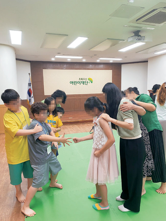 지난해 7월 초록우산 대구종합사회복지관에서 진행된 다문화가족 관계증진 프로그램 ‘핑퐁패밀리’에 참여한 아이들과 엄마들이 가위바위보 기차놀이를 즐기고 있다.   초록우산 제공