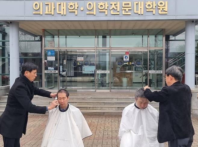5일 오전 강원 춘천시 강원대학교 의과대학 앞에서 의대 교수들이 대학 측의 증원 방침에 반발하며 삭발하고 있다. 강원대학교 의대 교수진 제공