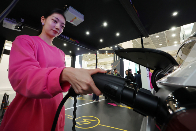 볼트업의 한 직원이 6일 서울 강남구 코엑스에서 열린 ‘EV트렌드코리아 2024’의 전시 부스에서 천장에 내려온 충전기로 충전 시연을 하고 있다. 연합뉴스