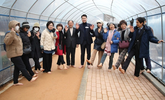 오언석(왼쪽 일곱 번째) 서울 도봉구청장이 지난달 27일 발바닥공원 황톳길을 찾아 맨발걷기 국민운동본부 관계자 및 주민들과 기념 촬영을 하고 있다. 도봉구 제공