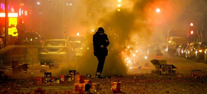 중국 최대명절 춘절 기간, 베이징 도심에서 한 남성이 폭죽에 불을 붙인 후 대피하고 있다. / 베이징 로이터=뉴시스