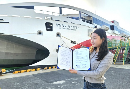 (주)대저페리 한 직원이  포항~울릉간 운항하는  정박중인 엘도라도 익스프레스호 앞에서  최근 대저페리와 대구고등법원이 체결한 업무협약서를 들어 보이고 있다(대저페리제공)