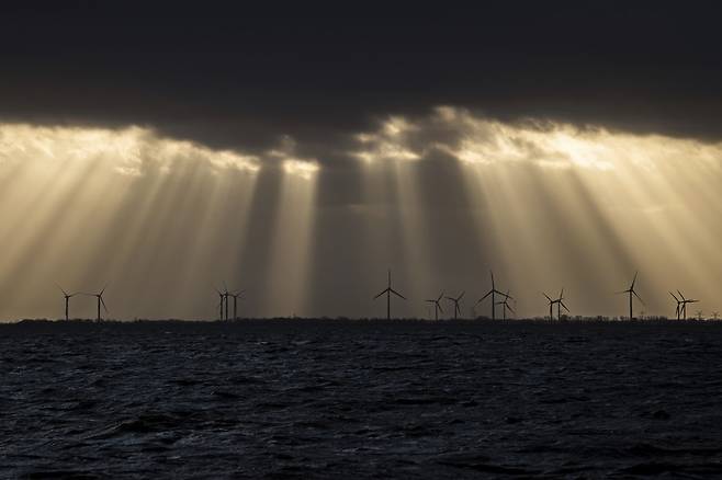 2019년 12월15일 독일 북해 연안 빌헬름스하펜에서 햇빛이 먹구름 사이로 풍력발전 단지를 비추고 있다.ⓒEPA