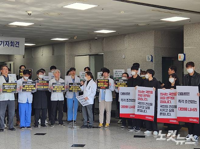 11일 오전 부산대학교 양산캠퍼스 의과대학에서 열린 기자회견에서 교수들과 의대 학생들이 피켓을 들고 증원에 반대하고 있다. 정혜린 기자