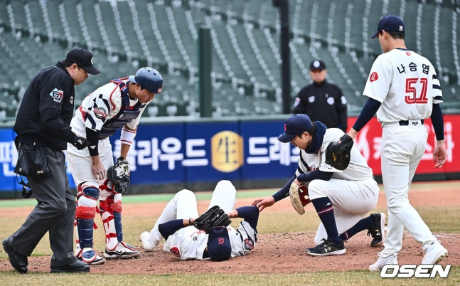 롯데 구승민(가운데)이 11일 사직 두산전에서 9회 초 김인태의 타구에 어깨를 맞고 쓰러졌다.