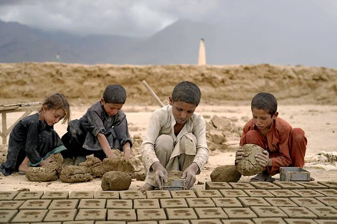 지난 7월 23일 카불 외곽의 한 벽돌공장에서 흙으로 벽돌을 만들고 있는 어린이들./AP 연합뉴스