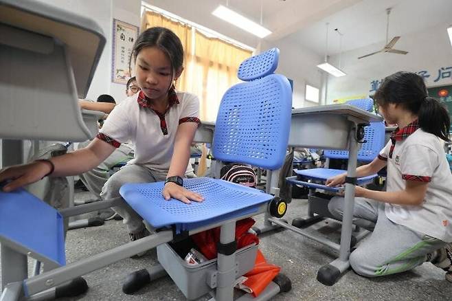 중국 저장성 후저우시 의  한 초등학교  학생들이 각자 자신의 책걸상을 침상으로 조정하고 있다./페이스북