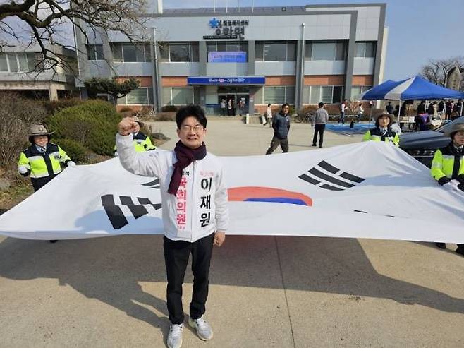 이재원 후보가 대형 태극기 앞에서 필승 결의를 다지고 있다. 선거사무소 제공