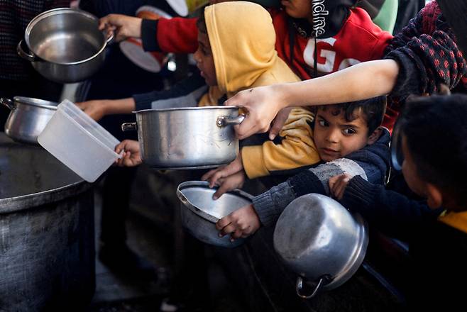 지난 5일(현지시간) 가자지구 남쪽 라파에서 팔레스타인 어린이들이 기부 급식소에서 급식을 기다리고 있다. 로이터연합뉴스