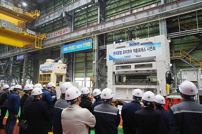 12일 현대로템 당진공장에서 진행된 ‘적층 프레스’시연회에서 참석자들이 적층 프레스 설비(오른쪽)와 배터리 캔 고속 프레스 라인(왼쪽)를 둘러보고 있는 모습. <현대로템>