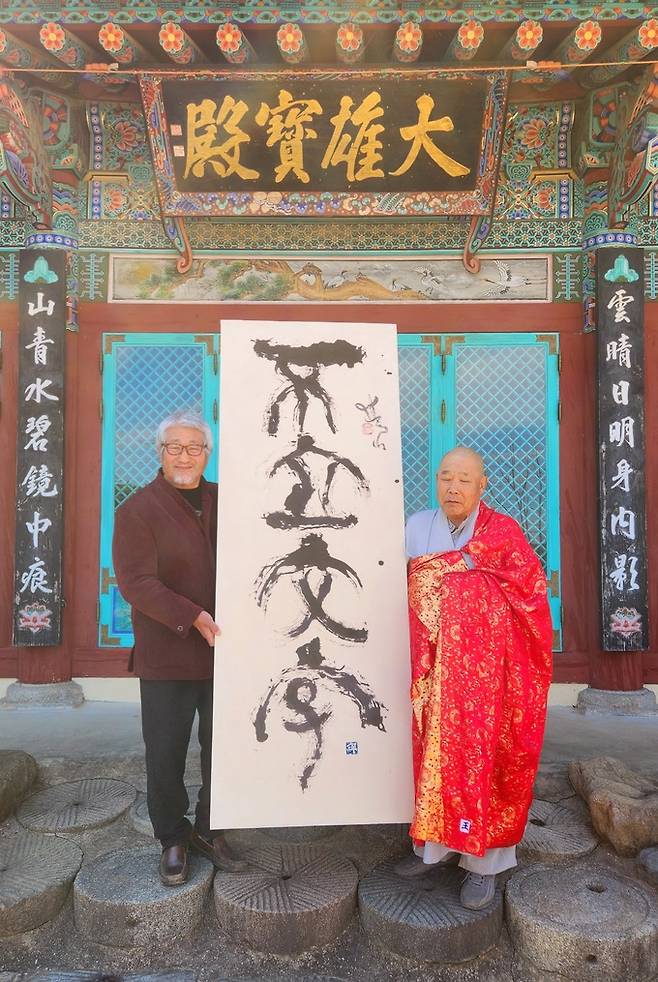 쌍산 김동욱(왼쪽) 서예가는 13일 오후 달마사를 찾아 자신의 작품을 기증한 가운데 달마사 종정 법은스님(오른쪽)과 기념촬영을 하고 있다. 김동욱 서예가 제공