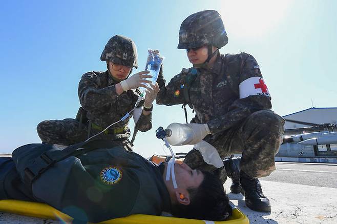 [서울=뉴시스] 13일,자유의 방패(FS) 연습 일환으로 진행된 전시 한미 연합 의무지원훈련에서 해군 해상기동헬기(UH-60)로 이동한 해군 2함대 군 의료진이 덕적도에서 발생한 외상환자를 응급조치 하고 있다. (사진=해군 제공) 2024.03.14. photo@newsis.com *재판매 및 DB 금지