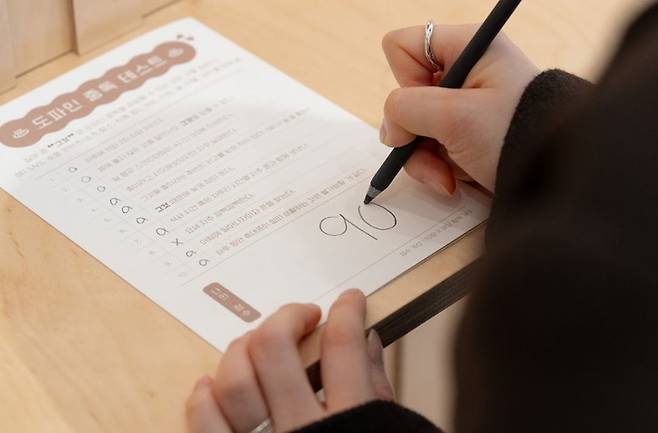 SK텔레콤이 운영하는 ‘송글송글 찜질방, 도파민 쫙 빼 드립니다’라는 체험 전시장을 찾은 이용객이 도파민 중독 자가 테스트를 하는 모습 / SK텔레콤 제공.