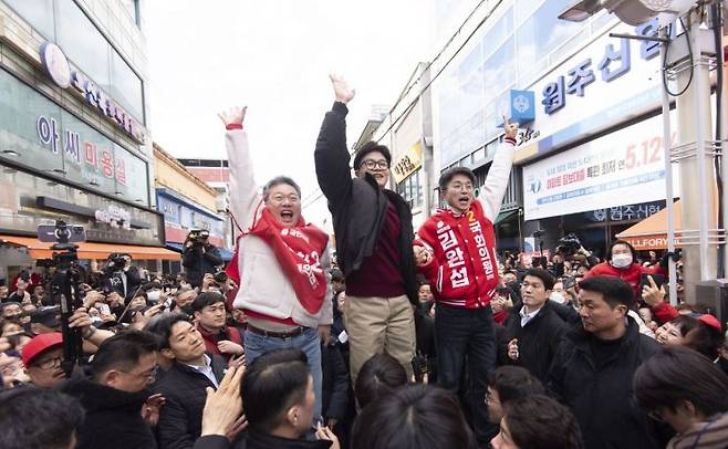 한동훈 국민의힘 비상대책위원장이 2월 26일 강원 원주 중앙시장을 방문해 시민들을 향해 인사하고 있다. 왼쪽은 박정하 의원, 오른쪽은 김완섭 예비후보. [사진출처=연합뉴스]