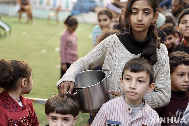 [가자시티=신화/뉴시스] 지난 13일(현지시각) 가자지구 가자시티에서 팔레스타인 어린이들이 구호 식량을 받기 위해 줄 서 있다. 2024.03.14.