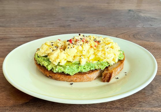 부드러운 계란과 바삭한 빵의 식감을 즐길 수 있는 아보카도 스크램블에그 토스트. 사진 김희경