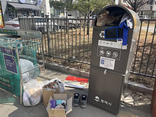 평택 고덕신도시 16블록 상가주택 밀집촌의 재활용품 수거함. 근로자들이 버리고 간 작업화가 놓여 있다. 박시온 기자