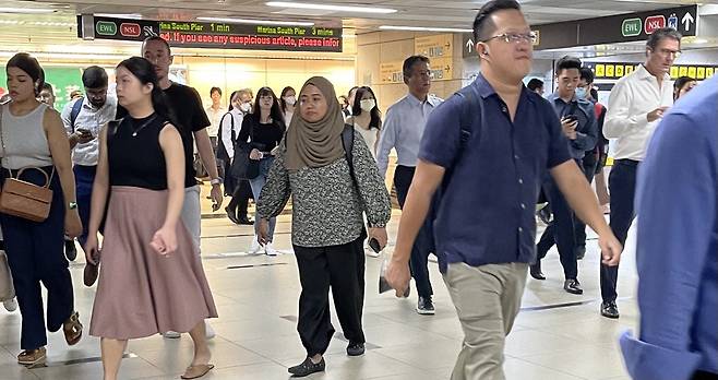지난달 1일 싱가포르 중앙업무지구 래플스 플레이스역에서 다양한 생김새의 직장인들이 근무지로 향하고 있다.  싱가포르 권한울 기자