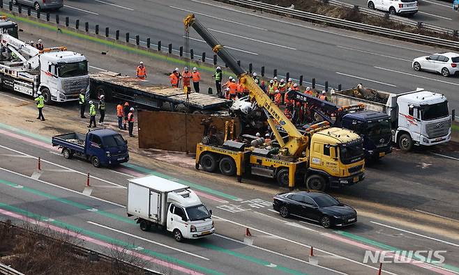 [성남=뉴시스] 김근수 기자 = 19일 경기 성남시 경부고속도로 판교IC 인근 서울 방면 도로에서 한국도로공사 직원들이 도로에 쏟아진 잔해물을 정리하고 있다. 소방과 경찰에 따르면 이날 오전 6시쯤 경기 성남시 인근 경부고속도로 판교IC 양재방면 도로에서 A(60대)씨가 몰던 25톤 트레일러와 B(50대)씨가 운전하던 25톤 덤프트럭이 충돌했다. 2024.03.19. ks@newsis.com