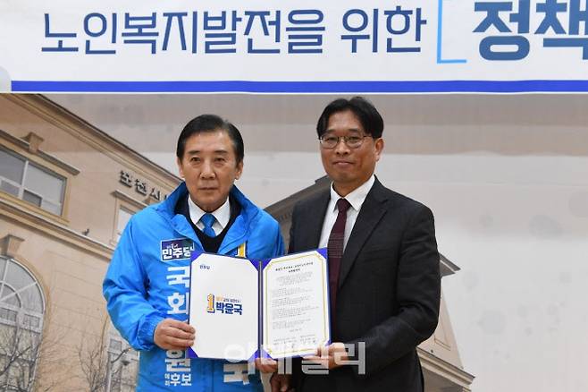 박윤국 예비후보(왼쪽)와 포천시노인복지관 관계자가 협약서를 들어보이고 있다.(사진=후보 제공)