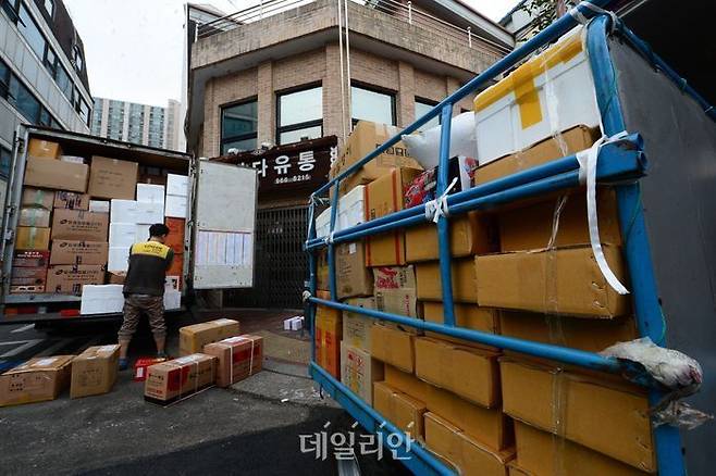 서울의 한 전통시장에서 택배직원이 수북하게 쌓인 박스를 옮기고 있다.ⓒ뉴시스