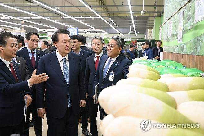 윤석열 대통령이 18일 서울 서초구 농협 하나로마트 양재점에서 무 판매대를 찾아 농산품 물가를 점검하고 있다.연합뉴스