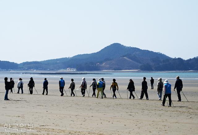 지난 15일 열린 '여행가는 달' 행사 참가자들이 신두리 해변에서 노르딕워킹 체험을 하고 있다.