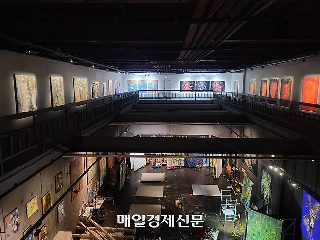 경기도 평택시 포승읍 ‘엠엠아트센터(mM ArtCenter)’에 마련된 박신양 기획 초대전 ‘제4의 벽’의 내부 모습. 2층에서 1층이 내려다 보이는 구조이다.  2층에 있는 관람객들이 박신양 씨가 1층에서 작업하는 모습을 볼 수 있도록 기획됐다. <사진=신수현 기자>