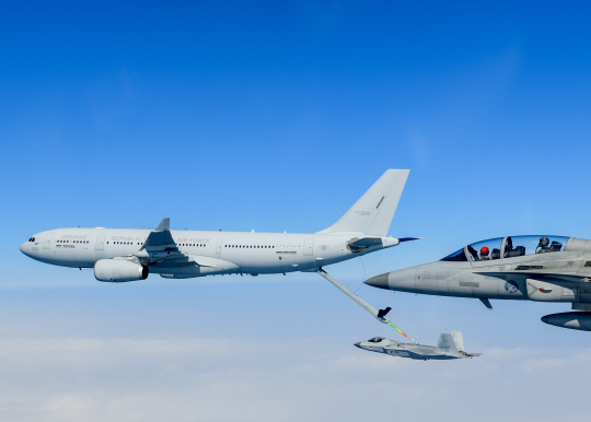 국산 초음속 전투기 KF-21 보라매 시제5호기(사진 아래)가 지난 19일 남해상에서  KC-330 다목적공중급유수송기(사진 왼쪽)로부터 첫 공중급유에 성공하는 장면.국산 FA-50 경전투기(오른쪽)가 공중급유 장면을 지켜보고 있다. 방위사업청 제공