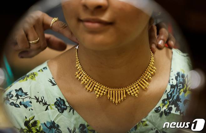 인도 뭄바이의 한 금은방에서 인도 여성이 목에 금목걸이를 착용해보고 있다. 2023.11.10 ⓒ 로이터=뉴스1 ⓒ News1 정지윤 기자