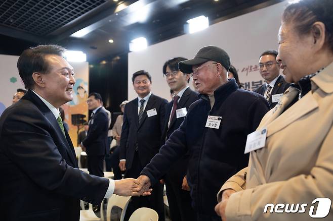 윤석열 대통령이 21일 강원 원주시 건강보험심사평가원에서 ‘건강하고 행복한 노후’를 주제로 열린 22번째 국민과 함께하는 민생토론회에서 노인맞춤돌봄서비스 보호자 남수현 씨와 악수하고 있다. (대통령실 제공) 2024.3.21/뉴스1 ⓒ News1 안은나 기자