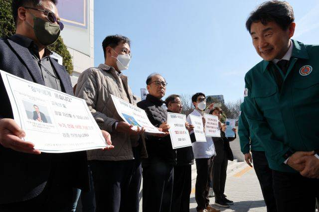 의대 증원에 반발한 의대 교수들 지난 13일 전북대학교를 방문한 이주호 부총리 겸 교육부 장관이 지나가는 옆에서 팻말을 들고 시위를 하고 있다. 연합뉴스