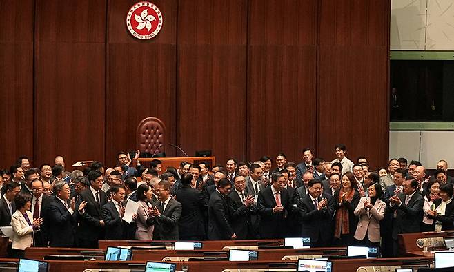 지난 19일 홍콩 입법회에서 입법의원들이 홍콩판 국가보안법 통과 직후 기념사진 촬영을 위해 모여 박수를 치고 있다. 로이터연합뉴스