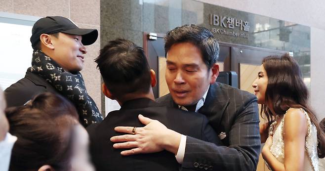 정용진 신세계그룹 회장이 작년 12월 23일 서울 서초구 예술의전당에서 아내 한지희씨의 플루트 독주회 공연을 도운 범키와 포옹하고 있다. 한씨는 범키의 소속사 대표 라이머(왼쪽)와 인사를 나누고 있다. /뉴스1