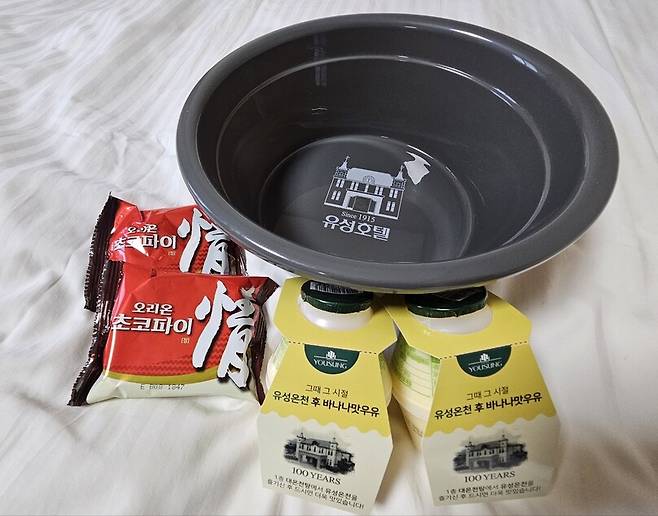지난 14일 유성호텔에 놓여 있던 바나나맛 우유와 초코파이, 체크인하며 받은 ‘굿바이 이벤트’ 굿즈인 목욕 바가지. 최예린 기자