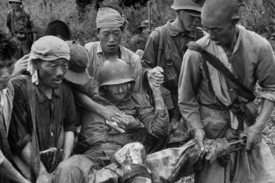 한국군과 민간인들이 부상당한 미군 해병 1인을 기관총을 이용해 만든 간이 들것에 실어 나르고 있다. /Life(Photography by David Douglas Duncan. 1950)